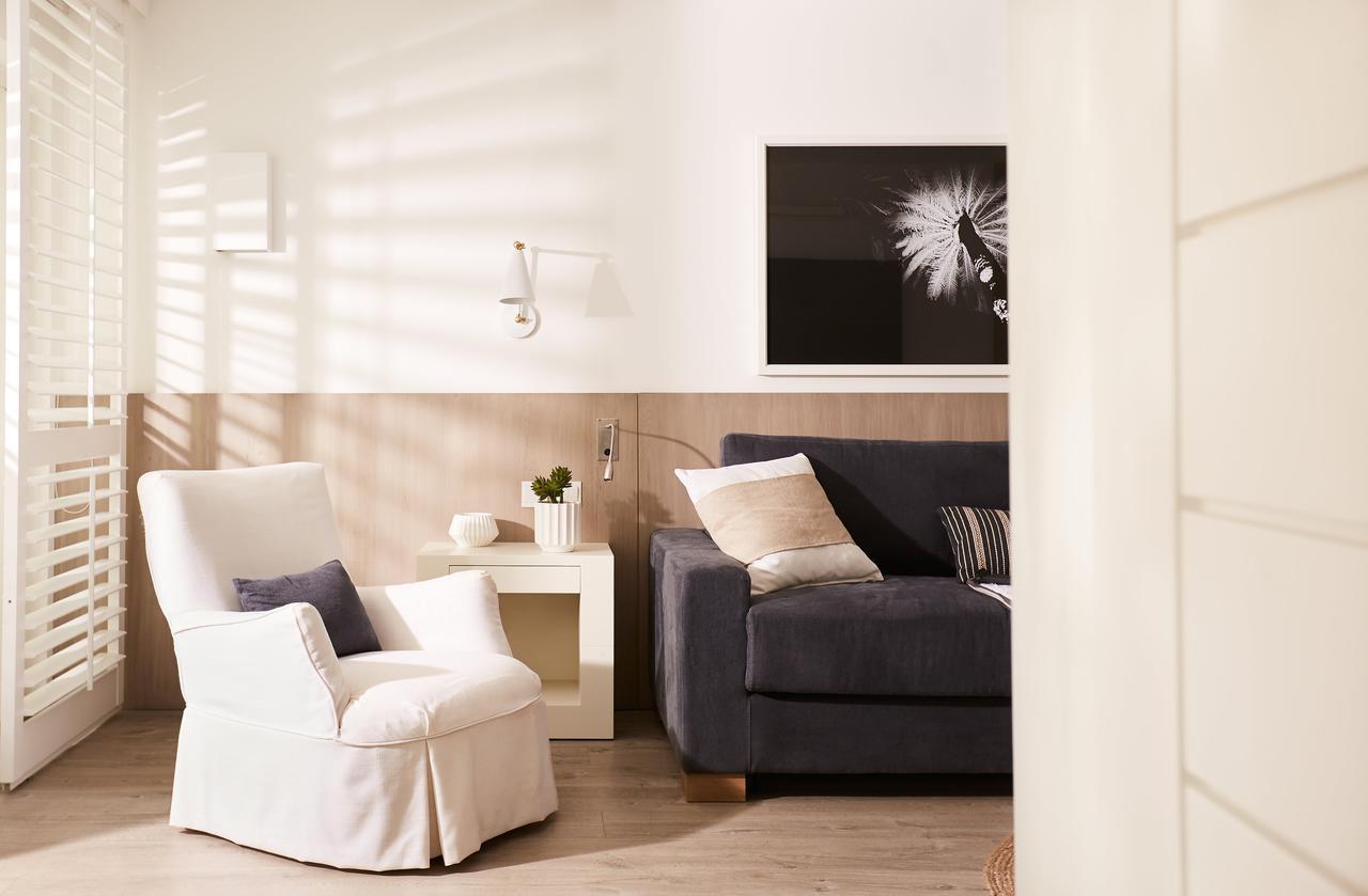 럭스* 그랜드 가우베 호텔 그랑고브 외부 사진 A living room with a white armchair and a blue sofa